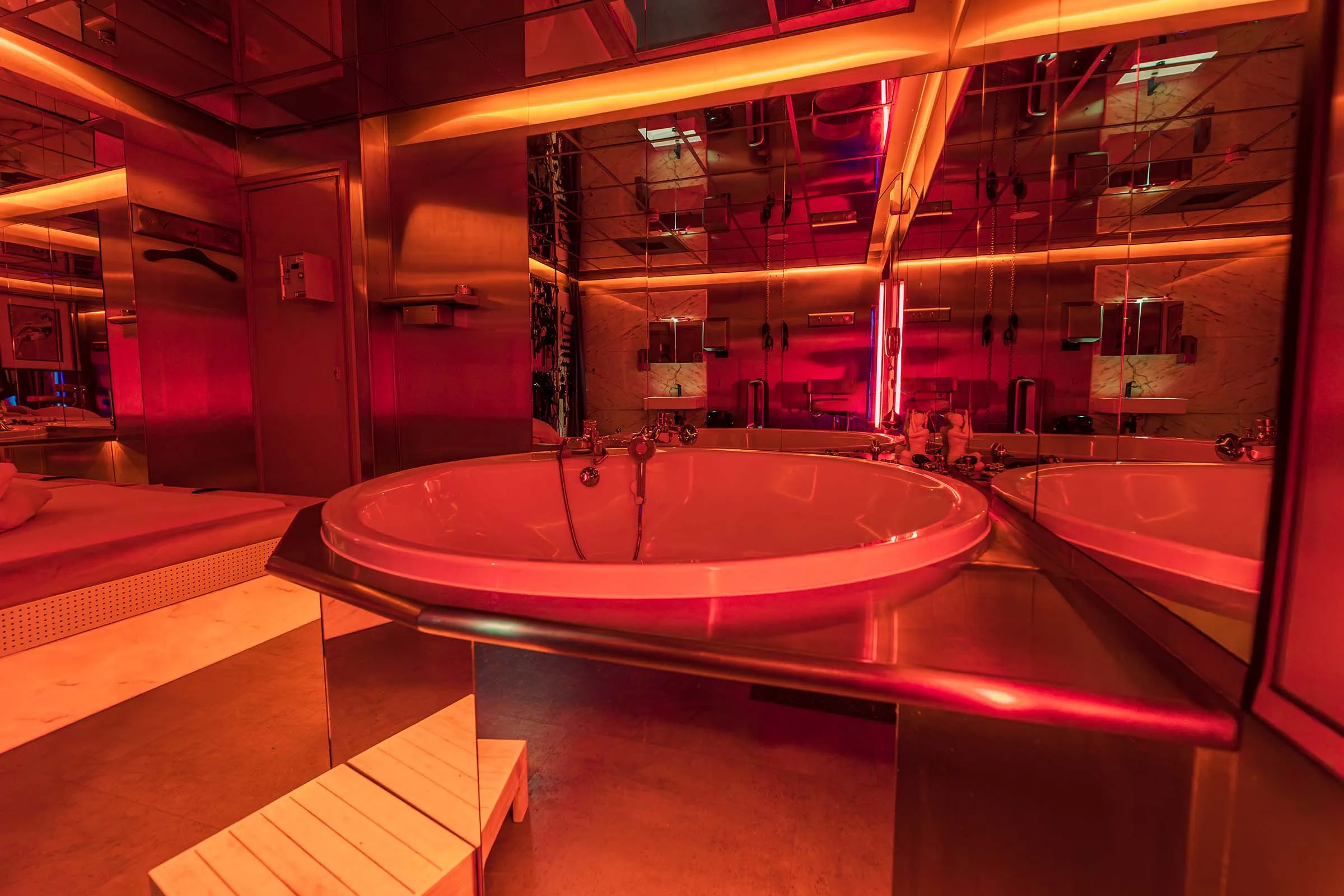 Een kamer met bubbelbad, in warm gedempt licht.